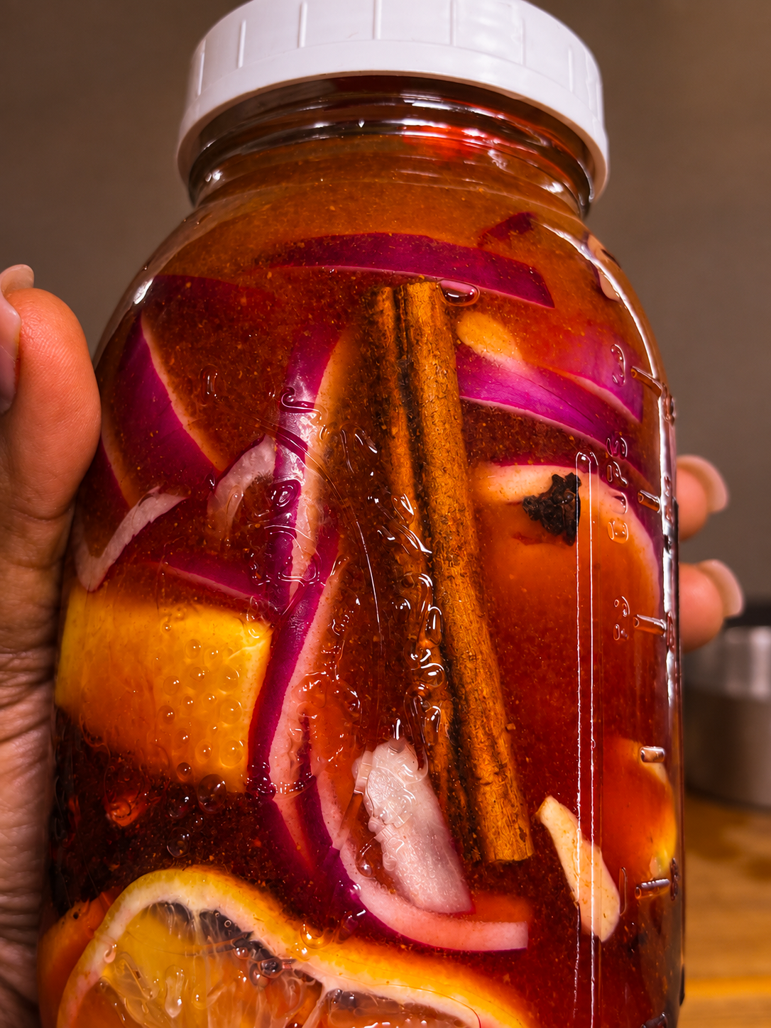 Ceylon cinnamon, red onion, citrus, and garlic in hibiscus fire cider
